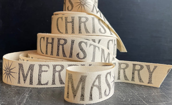 natural cotton ribbon with Merry Christmas in charcoal print and a Art Nouveau font.