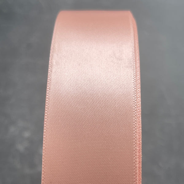 Pink satin ribbon on a gray background