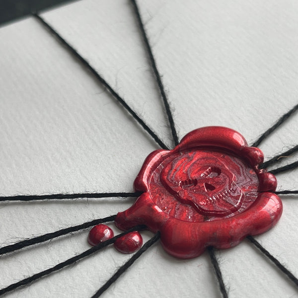 skull wax seal with black thread on a white gift 