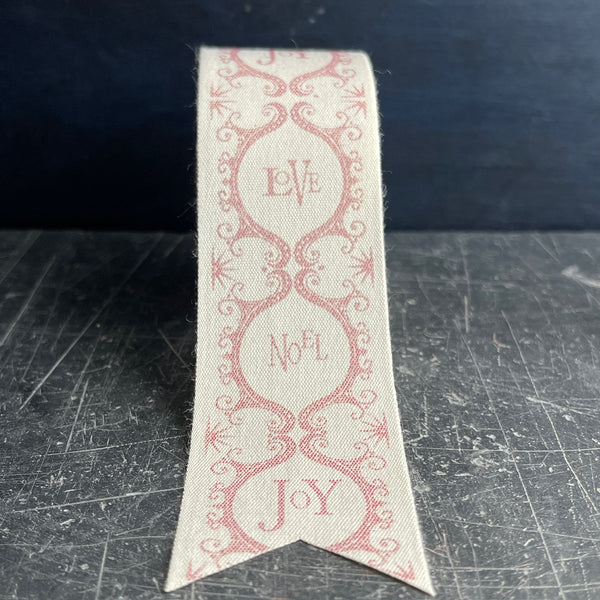 ornamental Christmas ribbon with red print and Love, Noel and Joy wording 